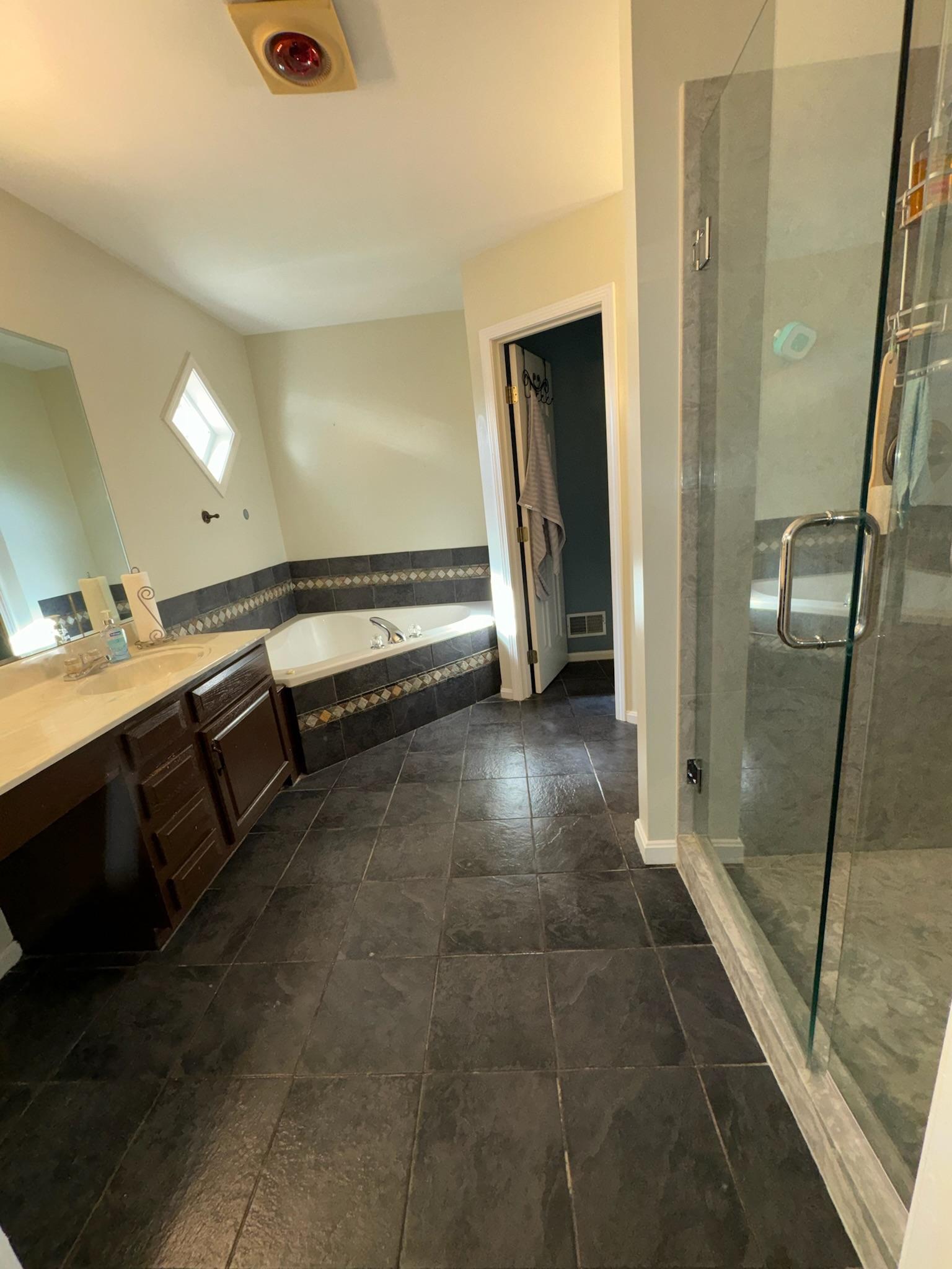 A guest-ready bathroom with a soaking tub and glass shower, cleaned between stays