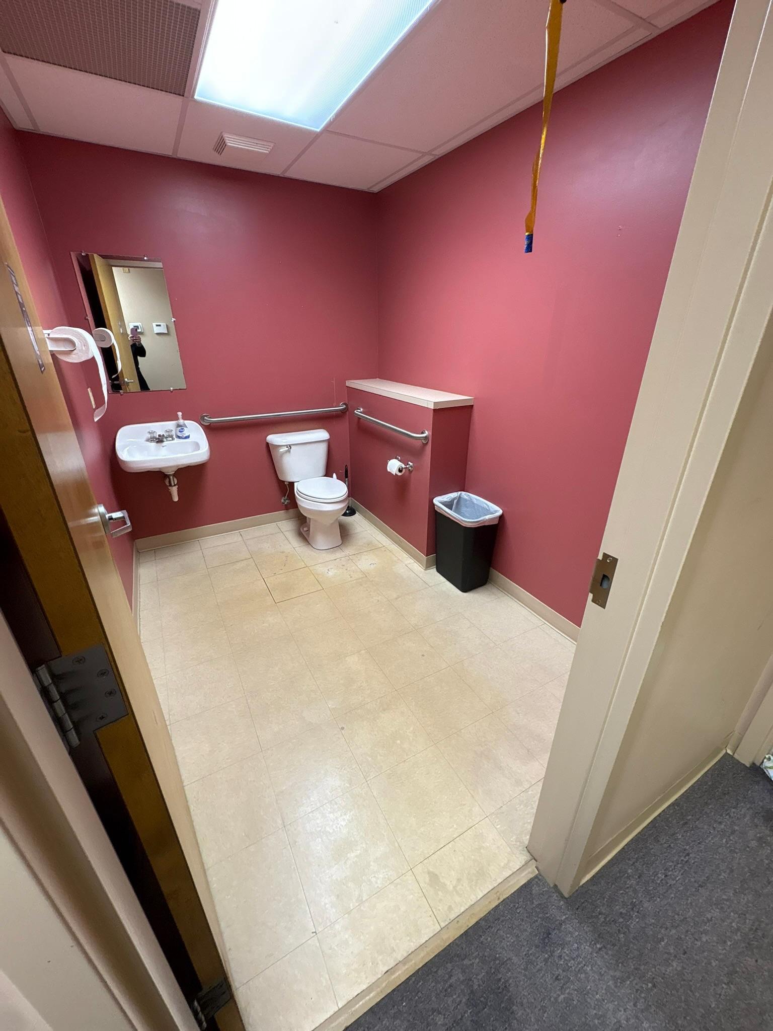 A commercial restroom cleaned and restocked, floors mopped
