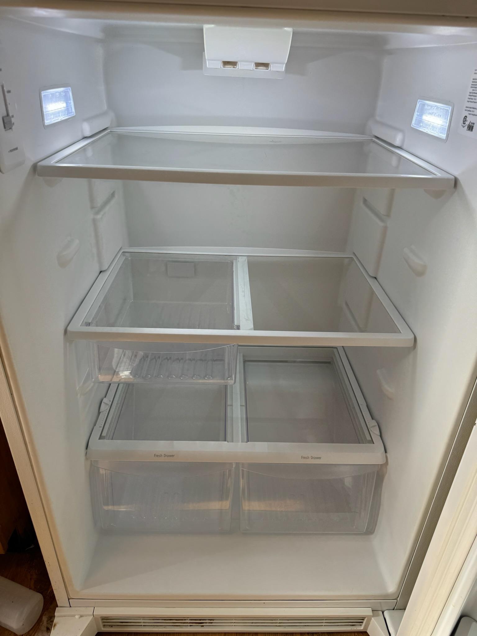 The same refrigerator interior after cleaning: shelves and drawers scrubbed white and streak-free